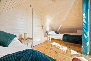 Habitación con 2 camas en una cabaña de madera en Natura Jantar - Całoroczne domy drewniane, en Jantar