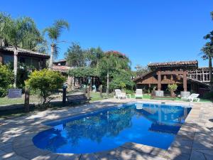 a swimming pool in front of a house at Pousada Meia Lua in Praia do Rosa