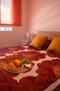 un plato de comida en una cama con dos vasos de zumo de naranja en Apartamento Veronika en Arrecife