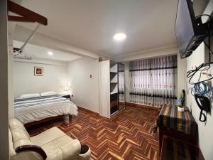 瓦拉斯Hospedaje apus的一间带床、沙发和电视的卧室