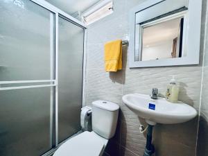 Un baño con inodoro, lavabo y ducha. en Hospedaje Santaisa, en Cali 36 fotos más