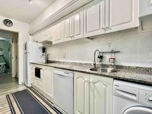 a kitchen with white cabinets and a sink at Evinrude 2 in Sant Carles de la Ràpita