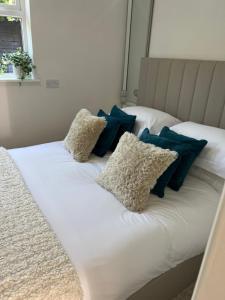 Una cama blanca con almohadas azules. en The Sanctuary, en Exmouth