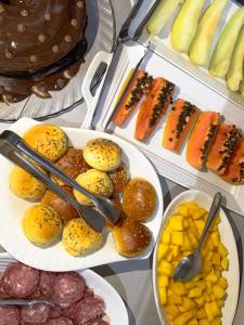 una mesa cubierta con platos de diferentes tipos de alimentos en Hotel Ideal, en Chapecó