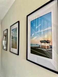 a group of three framed pictures on a wall at Cosy spacious home by the water With free parking in Portsmouth