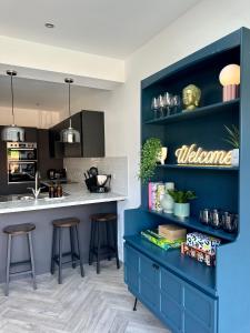 a kitchen with blue cabinets and a counter with stools at Cosy spacious home by the water With free parking in Portsmouth