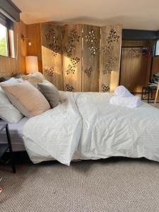a large bed with white sheets and pillows on it at Classy House Boat on Penton Hook Marina - walking distance Thorpe Park in Thorpe