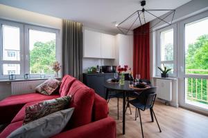 ein Wohnzimmer mit einem roten Sofa und einem Tisch in der Unterkunft FREEDOM APART - Długa 8m6 in Zielona Góra