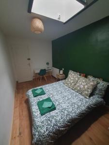 1 dormitorio con 1 cama con pared verde en Maison de rue: Auch, en Auch