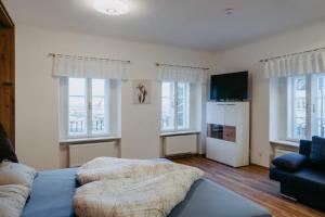 a bedroom with a bed and a couch and windows at Schloss-Appartements in Eisenstadt
