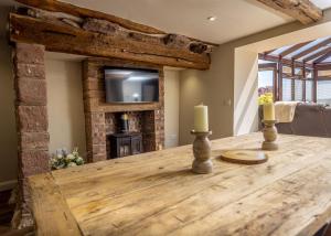a dining room with a wooden table and a fireplace at The Farmhouse, Sebergham, near Caldbeck in Sebergham
