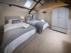 a bedroom with three beds and a cabinet in it at The Farmhouse, Sebergham, near Caldbeck in Sebergham +18 photos