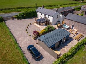 an aerial view of a house with a car parked in the driveway at The Farmhouse, Sebergham, near Caldbeck in Sebergham