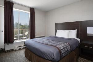 a hotel room with a bed and a balcony at Super 5 Inn in Mississauga