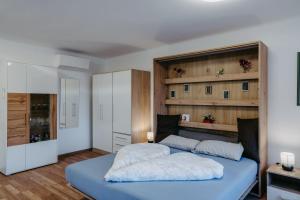 a bedroom with a blue bed with two white pillows at Schloss-Appartements in Eisenstadt