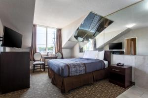 a hotel room with a bed and a mirror at Super 5 Inn in Mississauga