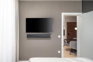 a bedroom with a flat screen tv on a wall at Upper Premium Apartments in Rijeka