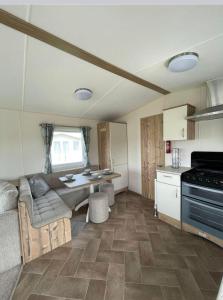 a kitchen with a couch and a table in a room at Staycation For You (Kent) in Leysdown-on-Sea