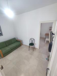 a living room with a green couch and a table at Calm place and near to the beach in Monastir