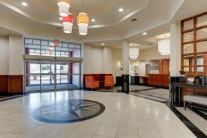 un gran vestíbulo con una sala de espera con sillas y mesas en Drury Inn & Suites Montgomery, en Montgomery