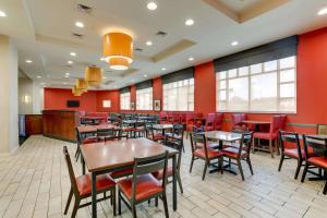 un restaurante con mesas, sillas y paredes rojas en Drury Inn & Suites Montgomery, en Montgomery