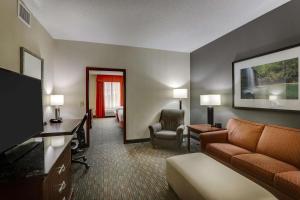 a hotel room with a couch and a television at Drury Inn & Suites Montgomery in Montgomery