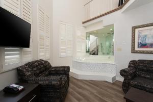 a living room with two chairs and a tv and a tub at Super 5 Inn in Mississauga