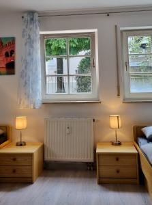 a bedroom with two lamps and a bed and two windows at Ferienzimmer in der Altstadt in Wangen im Allgäu