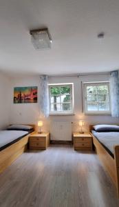 a bedroom with two beds and two windows at Ferienzimmer in der Altstadt in Wangen im Allgäu