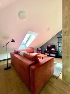 ein Wohnzimmer mit einem roten Sofa und einem Dachfenster in der Unterkunft SKY Apartments in Kaunas