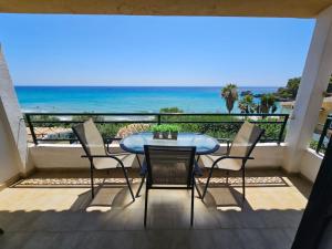 a table and chairs on a balcony with the ocean at Corfu Dream Holidays Villas in Glyfada