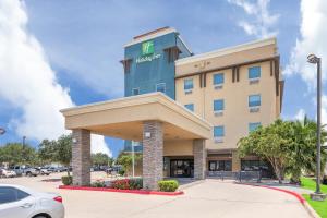 ein Hotelgebäude mit einem davor geparkt in der Unterkunft Holiday Inn - Brownsville, an IHG Hotel in Brownsville