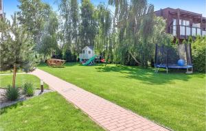 a garden with a playground and a house at 1 Bedroom Pet Friendly Home In Dabki in Dąbki