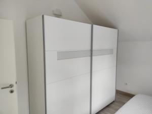 a white wardrobe with glass doors in a bedroom at Veronika,Beppo,Coolio apartments in Mirce