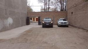 two cars parked in a parking lot next to a brick wall at Centrico 07 in General Roca