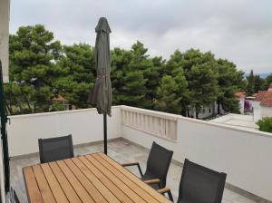a patio with a table and an umbrella on a balcony at Veronika,Beppo,Coolio apartments in Mirce
