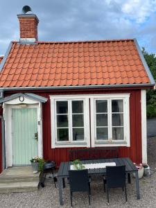 una casa rossa e bianca con tavolo e sedie di Gårdshus - best location in the center of Gränna a Gränna