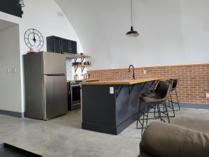 a kitchen with a refrigerator and a counter with stools at Unique waterfront house with private beach in Gananoque