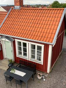 an orange roof on a red house with a table at Gårdshus - best location in the center of Gränna in Gränna