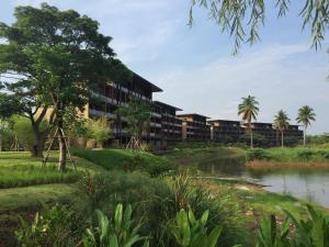 an exterior view of a building next to a river at atta Lakeside Resort Suite - SHA Plus Certified in Mu Si +44 photos