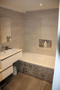 a white bathroom with a tub and a sink at Chalet les Pounets in Damprichard