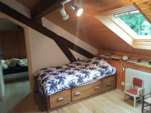 a bedroom with a bed and a desk and a window at Chalet les Pounets in Damprichard