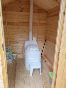 a bathroom with a toilet in a wooden room at Unique waterfront house with private beach in Gananoque