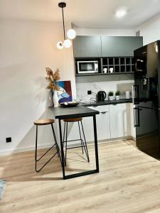 a kitchen with a black table and two stools at Apartament nad Zalewem w lesie in Serock