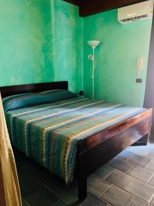 a bed in a room with a green wall at Marnabianca Apartment in Realmonte +35 photos