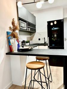 a kitchen with two bar stools at a counter at Apartament nad Zalewem w lesie in Serock