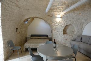 a living room with a table and a bed at Trullo Vino & Amore in Alberobello