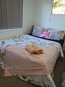 Una cama con toallas en un dormitorio en Auckland airport holiday home, en Auckland