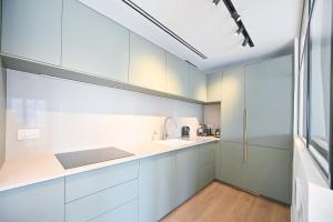 una cocina con armarios blancos y fregadero en Charming 1BR Apt in Authentic Bauhaus Building, en Tel Aviv