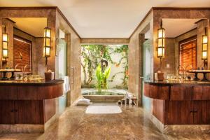 a bathroom with two sinks and a tub at The Oberoi Beach Resort, Lombok in Tanjung